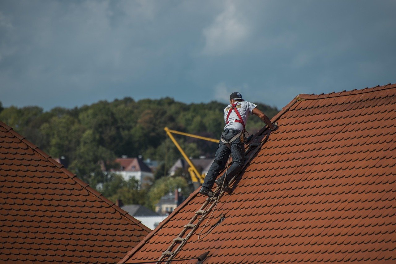 Dachdecker bei Arbeiten auf einem Ziegeldach