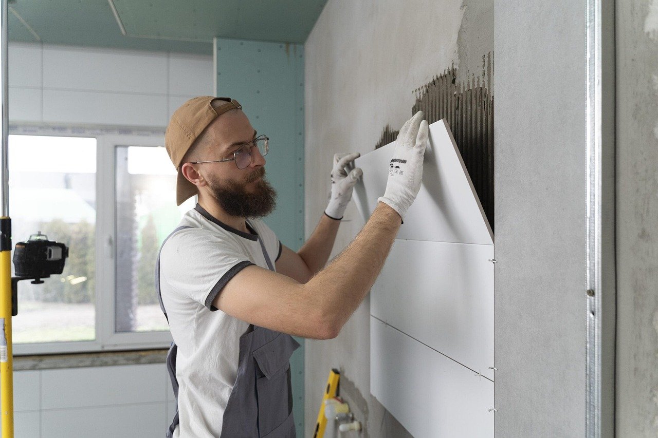 Fliesenleger bei der Arbeit an einer Wand